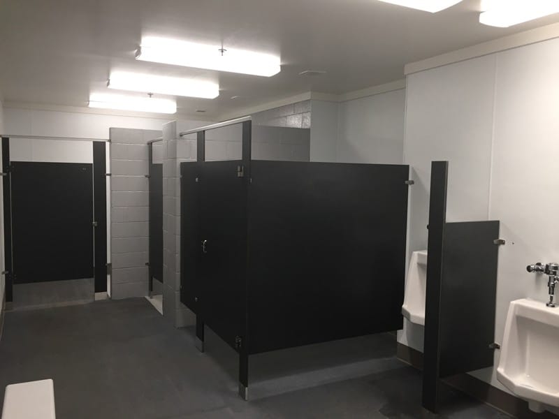 Multiuser Restroom with Concrete Stalls for Private Changing Rooms