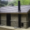 Large Waterless Bathroom Structure with Stone Wainscot Exterior and Steel Fixtures