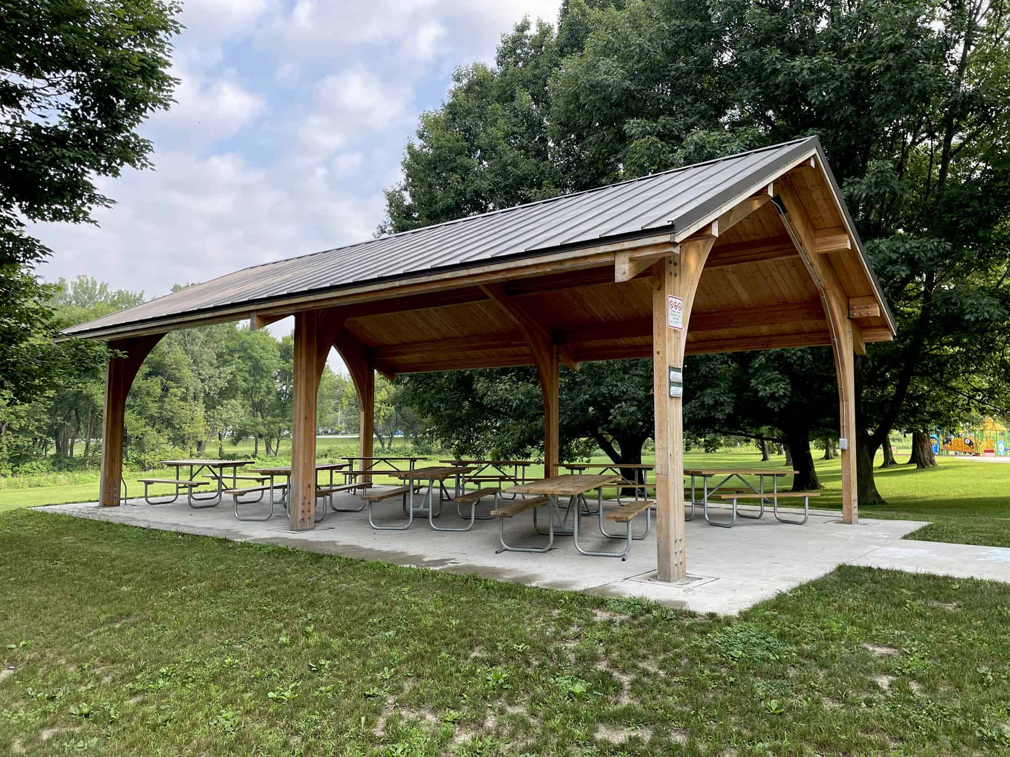 Customized park pavilion with arched entrance and shelter for picnic tables