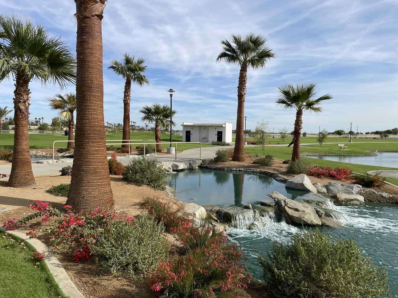 SilverRock-Resort-Venue-Site-Restroom-3 A white restroom in the background of an upscale california golf course with palm trees and a water feature.