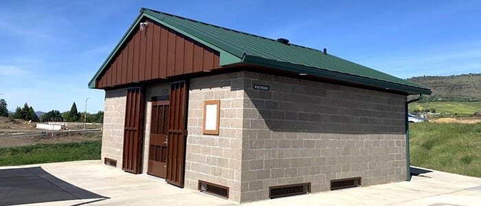 A restroom and storm shelter building with added security doors