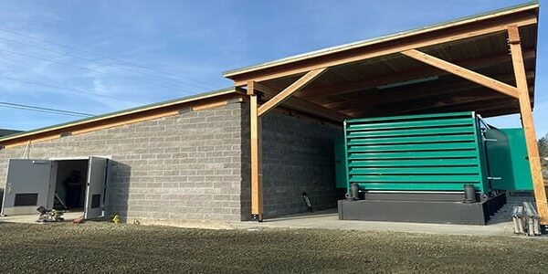 A large booster station building with a porch extension covering a large generator.
